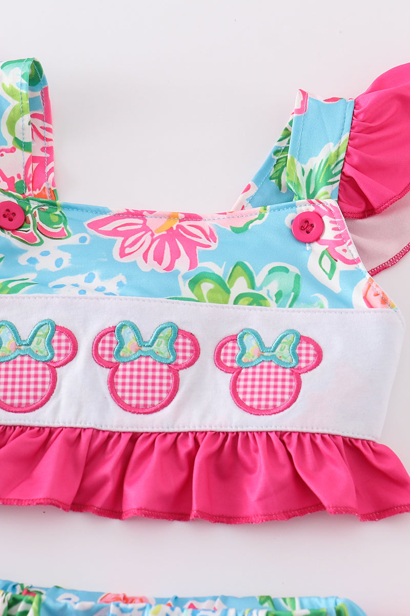 Close-up of Minnie-inspired ears and character appliqué on a girls' pink floral 2-piece swimsuit top.