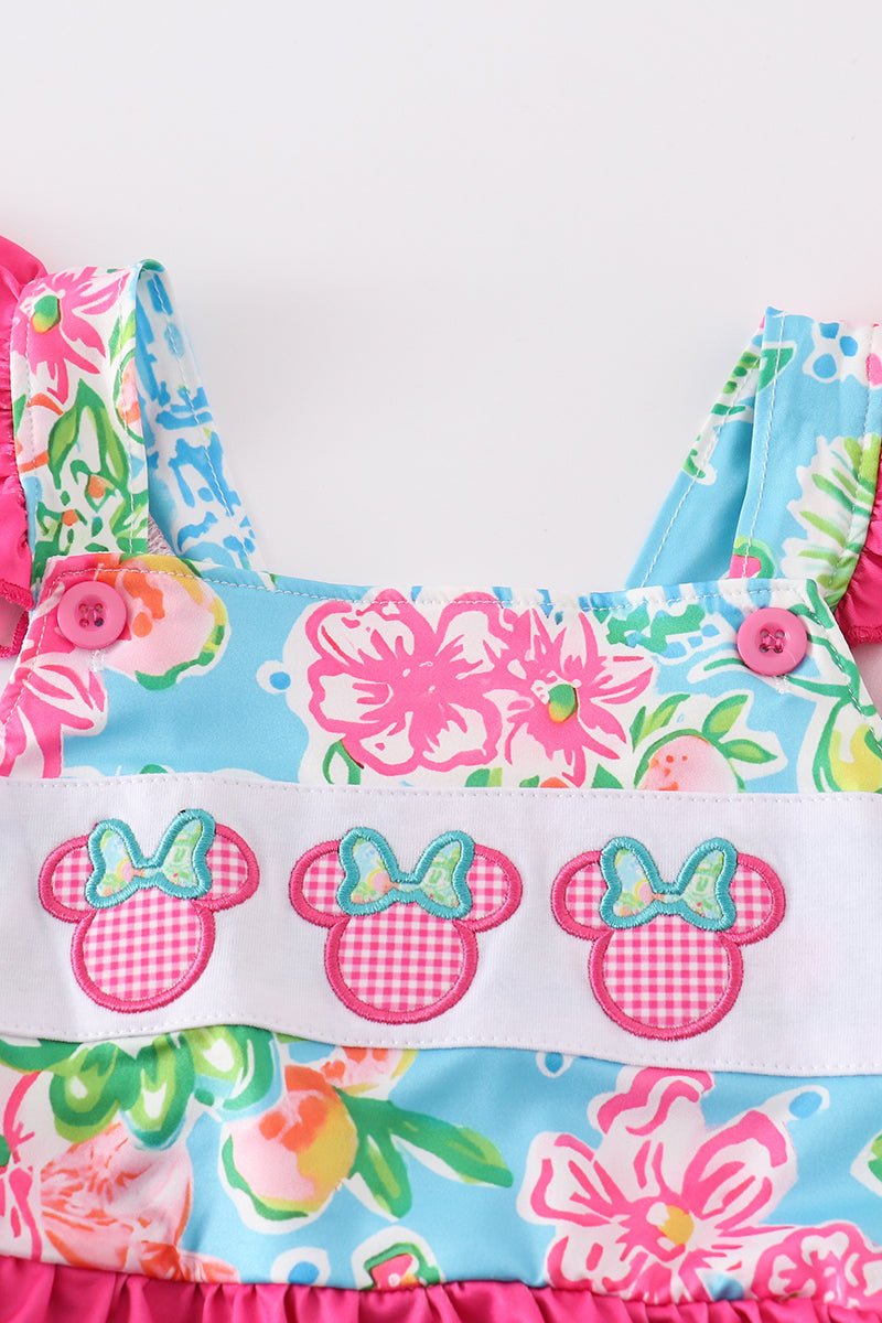 Close-up of Minnie-inspired ears and character appliqué on a girls' pink floral swimsuit.