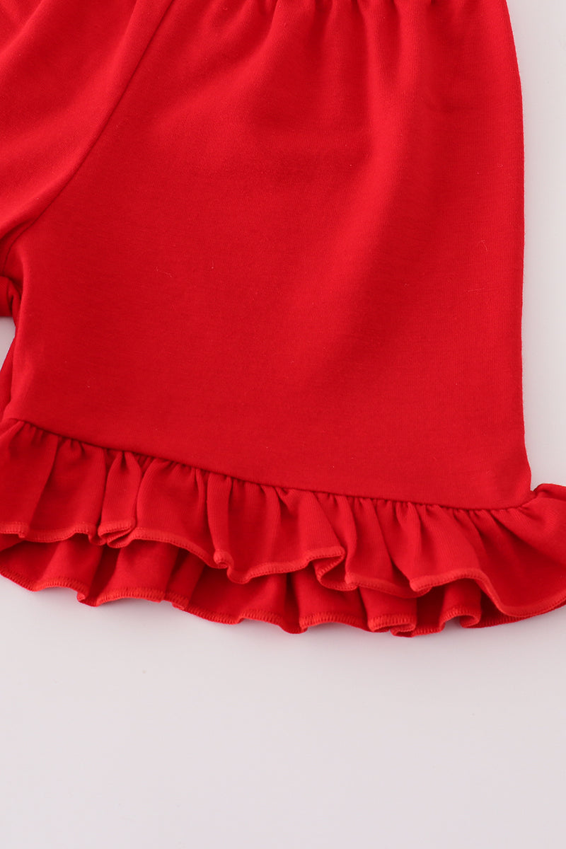 Toddler girl wearing a cute red apple print shorts set with ruffles and a bow from Cloudling Kids, perfect for summer fun.