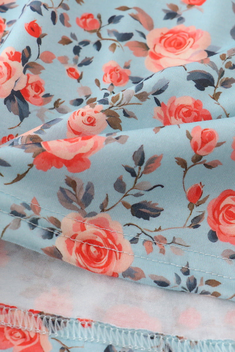 Close-up of smocked bodice and blue floral print on a girls' dress.