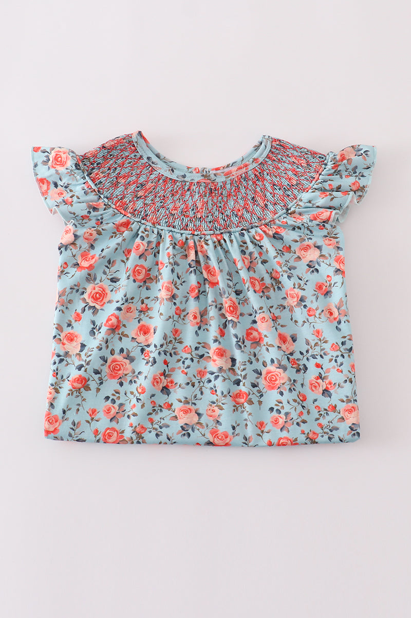 Adorable girls' blue smocked dress featuring a charming floral print.