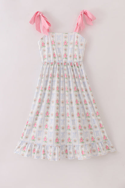Adult tea dress with floral print, bow detail, and ruffle trim.