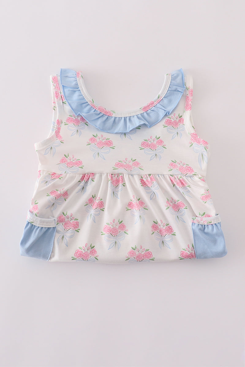 Baby girl summer outfit: blue floral top with bow and ruffle shorts.