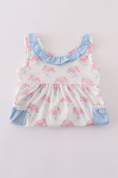 Baby girl summer outfit: blue floral top with bow and ruffle shorts.