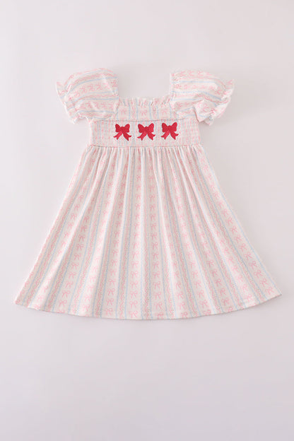 Girls pink smocked dress with bow embroidery.