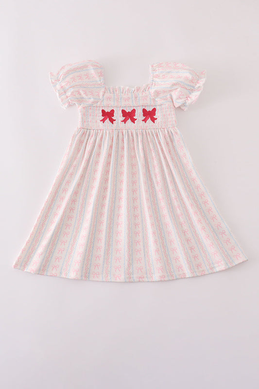 Girls pink smocked dress with bow embroidery.