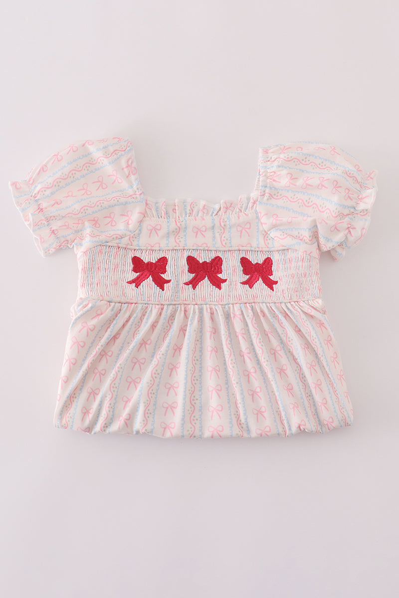 Elegant pink smocked dress for girls featuring bow embroidery.