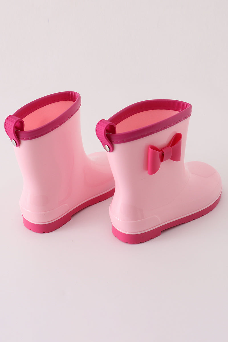 Adorable pink bow rain boots for kids, perfect for splashing in puddles.